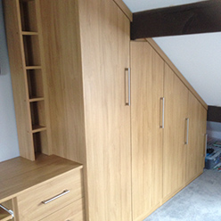 wood grain fitted wardrobes under sloped ceiling